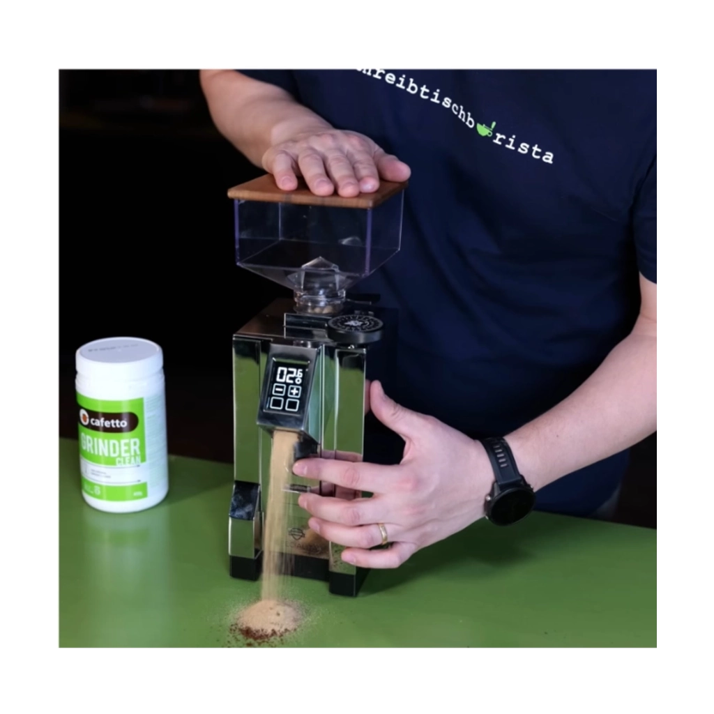 Cafetto Grinder Clean Mühlenreiniger bei der Anwendung in einer Espressomühle mit austretendem Reinigungsgranulat
