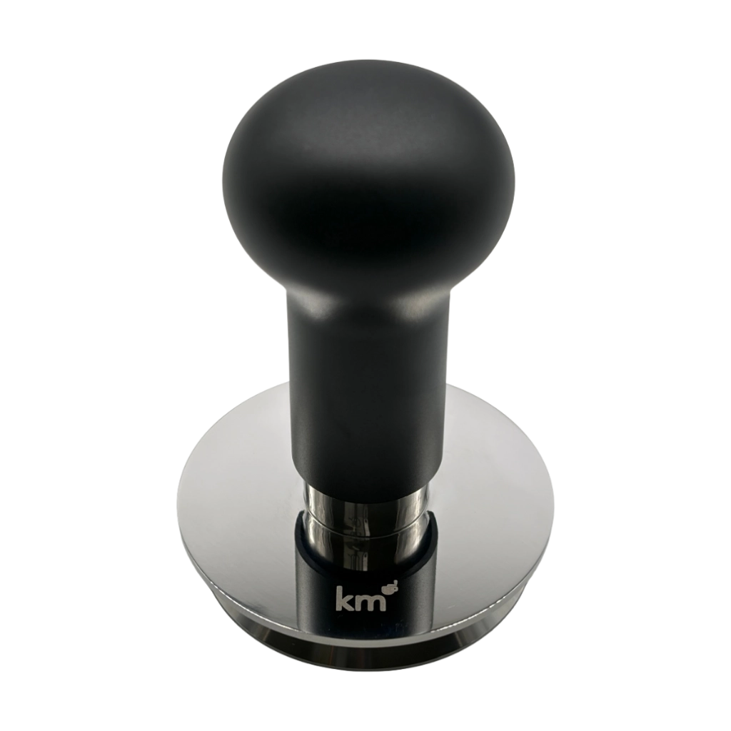 Kaffeemacher Profi-Drucktamper 58,55 mm in Schwarz aus erhöhter Perspektive mit ergonomischem Griff, Edelstahlbasis und KM-Logo