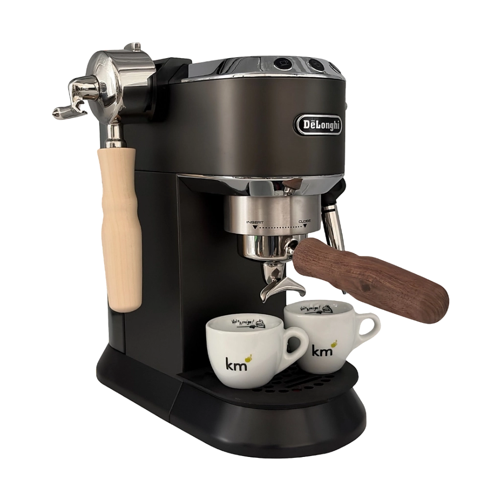 DeLonghi Dedica Espressomaschine mit montiertem Kaffeemacher Siebträger mit 2er-Auslauf und dunklem Holzgriff, zwei Espressotassen unter den Ausläufen sowie zweiter Siebträger-Variante mit hellem Holzgriff an der Seite.